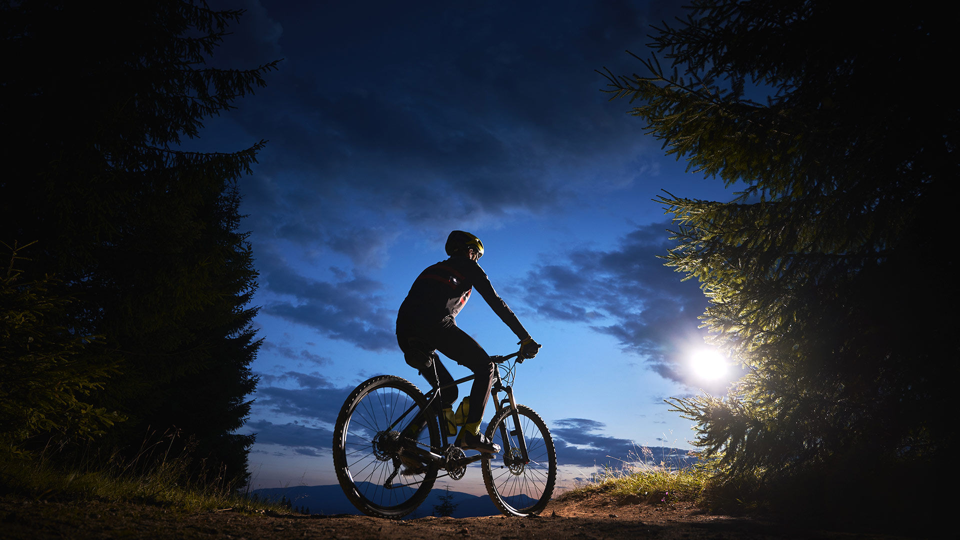 Una persona haciendo ciclismo de noche en un bosque